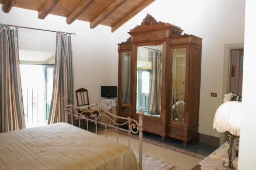 una camera da letto con cassettiera, letto e specchio di B&B Palazzo Gambino ad Acireale