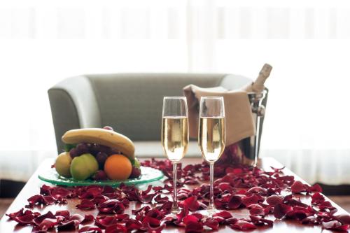 a table with two wine glasses and a plate of fruit at ISG Sabiha Gökçen Airport Hotel in Istanbul