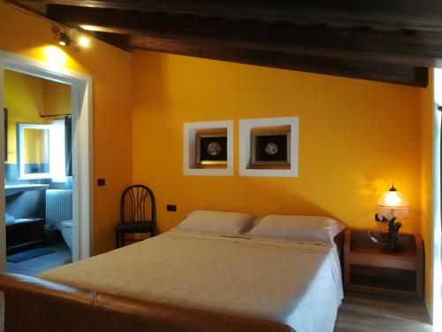 una camera con un grande letto e una parete gialla di Casa Degli Amici a Treviso