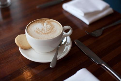 a cup of coffee on a plate on a table at The Headland Hotel and Spa in Newquay