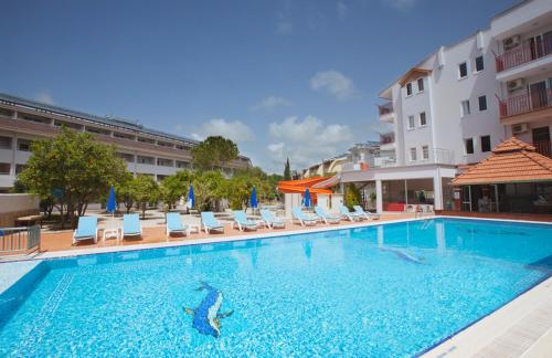a large swimming pool with chairs and a hotel at Catty Cats Garden Hotel in Side