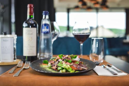 a plate of food on a table with a glass of wine at R hotel experiences in Sougné-Remouchamps