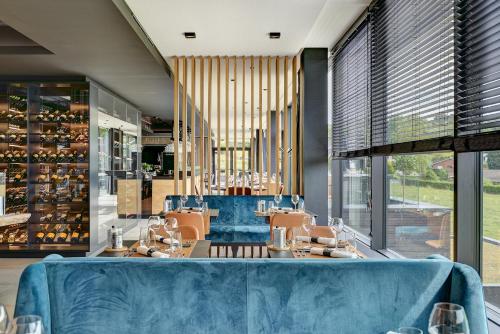 a restaurant with a blue couch in a room at R hotel experiences in Sougné-Remouchamps