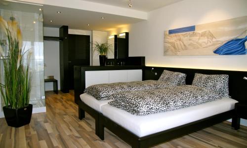 a bedroom with a black and white bed and plants at Hotel Restaurant Vogelsang in Eich