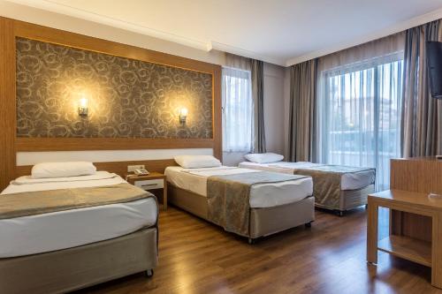 アランヤにあるLonicera City Hotelのベッド2台とテレビが備わるホテルルームです。
