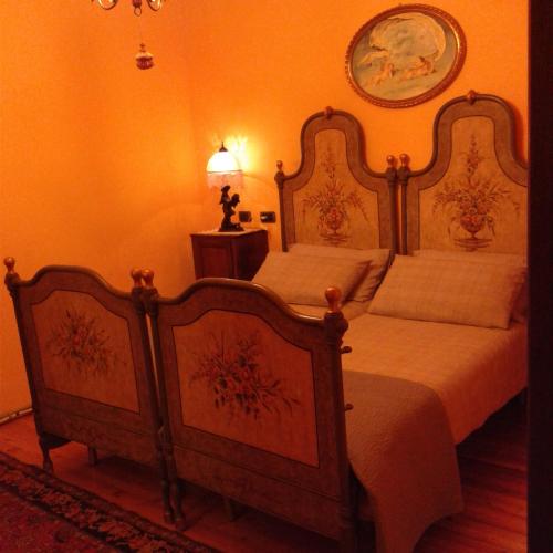 two beds in a bedroom with orange walls at Casa Degli Amici in Treviso