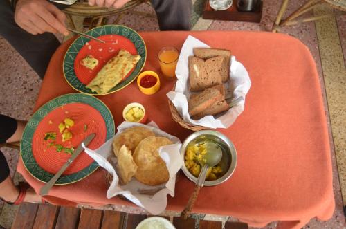a table with three plates of food on a table at Sneh Deep Guest House in Jaipur
