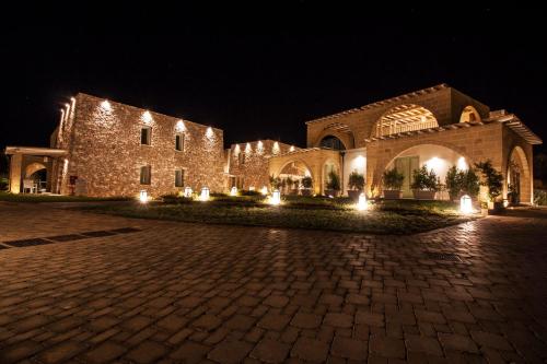 a large stone building with lights at night at Montiro' Hotel in Leuca