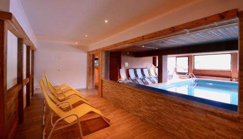 a swimming pool with chairs and a swimming pool at Landhaus Birgit in Telfes im Stubai