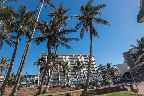 a hotel with palm trees in front of it at First Group Margate Sands in Margate