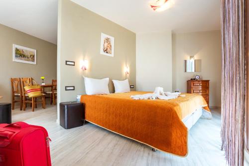 a hotel room with a bed and a red suitcase at ApartHotel Prostor in Kavarna