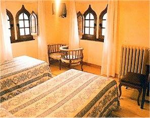 1 dormitorio con 2 camas, silla y mesa en Casa España, en Villaviciosa
