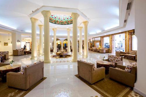 a lobby with chairs and tables in a building at Medina Belisaire And Thalasso in Hammamet