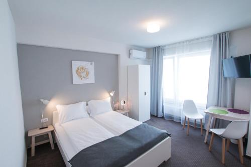a hotel room with a bed and a table and chairs at Victoriei City Studios in Bucharest