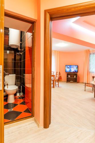 a bathroom with a toilet and a tv in a room at ApartHotel Prostor in Kavarna
