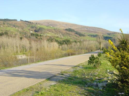an empty road with a mountain in the background at Hotel Balneario De Alceda in Alceda