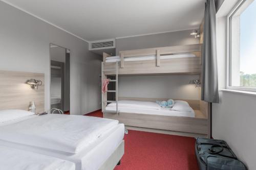 1 Schlafzimmer mit 2 Etagenbetten und einem Fenster in der Unterkunft Serways Hotel Spessart in Rohrbrunn