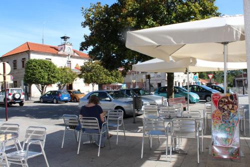 a woman sitting at a table under an umbrella at Nueva Colina in Tomiño