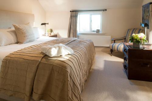 a bedroom with a bed with a white towel on it at Pheasants Nye in Higher Burwardsley