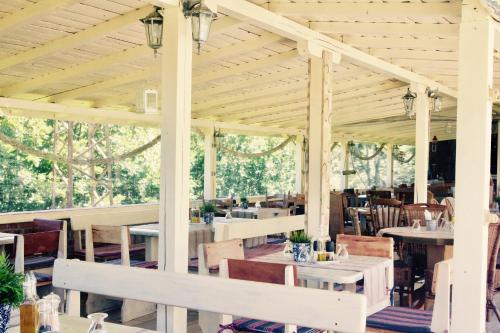a pavilion with tables and chairs in a restaurant at Hotel Anchor in Sinemorets
