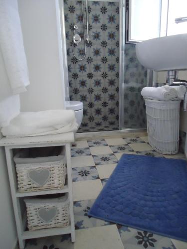 a bathroom with a toilet and a sink and a blue rug at Casa Bettina in Ostuni