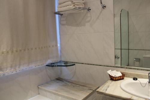 a bathroom with a sink and a shower with a mirror at Nueva Colina in Tomiño