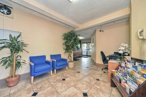 a waiting room with two blue chairs and plants at Red Carpet Inn - Stamford in Stamford