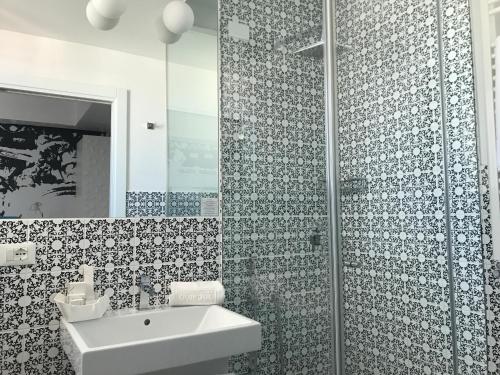 uma casa de banho com um lavatório e um chuveiro em QuiHotel em Porto Cesareo