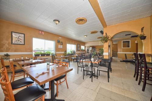 a dining room with wooden tables and chairs at Red Carpet Inn - Stamford in Stamford