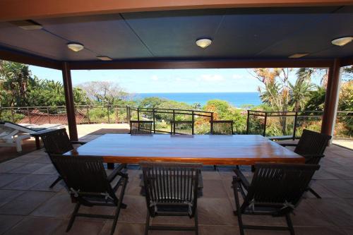 a large wooden table and chairs on a patio at Wailana lodge in Ramsgate
