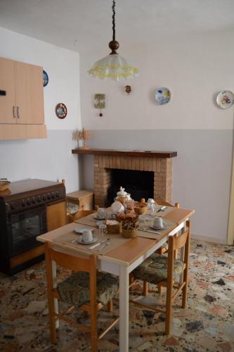 - une cuisine avec une table et une cheminée dans l'établissement Casa Vacanze Da Nonna Maria, à Guardiagrele