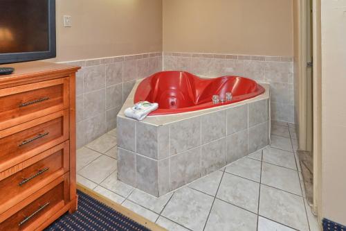 a red tub in the corner of a room at Red Carpet Inn - Stamford in Stamford