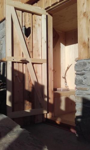 a wooden door in a room with a stone wall at Almhütte Gorgasser in Heiligenblut