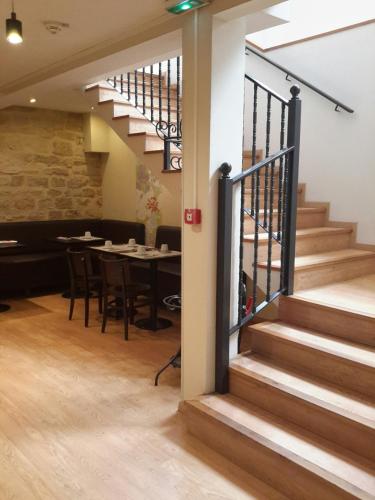 a staircase leading up to a dining room with a table at Hotel Cosmos in Paris