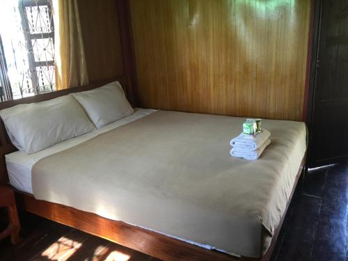 a bed with two towels on top of it at Dalom Guesthouse in Don Det