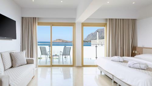 a bedroom with two beds and a view of the ocean at Zephyros Hotel in Myrties