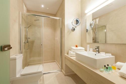 a bathroom with a shower and a sink and a toilet at Zephyros Hotel in Myrties