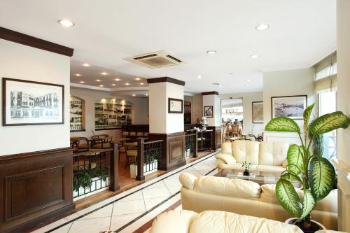 a large living room with couches and a plant at Izmir Palas Hotel in İzmir