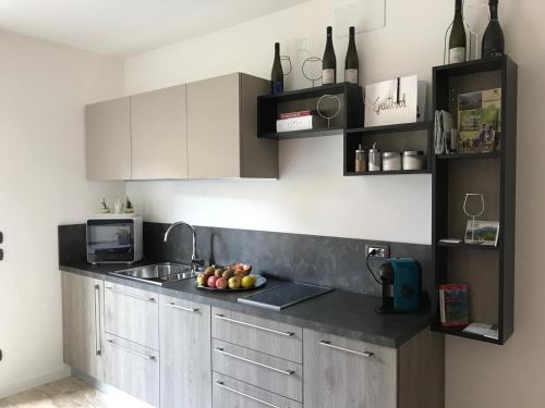 a kitchen with a sink and a bowl of fruit on the counter at Nenez B&B in Giovo