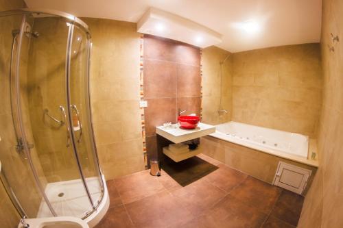 Leones的住宿－Hotel Posada Maestosso，带浴缸、淋浴和盥洗盆的浴室