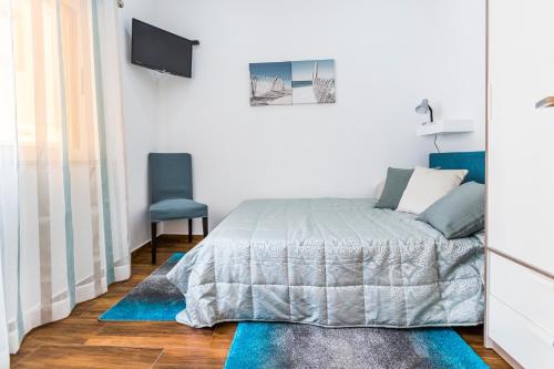 a bedroom with a bed and a blue chair at Casa Laranjinha in Albufeira