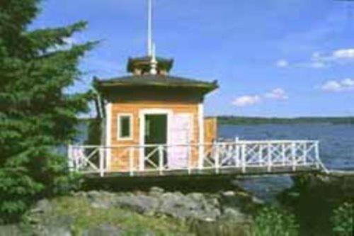 a small lighthouse on top of a rock near the water at Mälby Säteri B&B in Gnesta