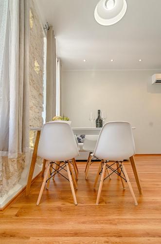 two white chairs sitting next to a table in a kitchen at Apartment Zora & Natale in Pula
