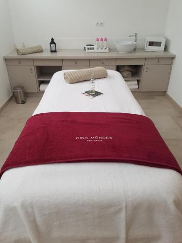 a bed with a red blanket on top of it at Hotel Spa Les Rives Sauvages in Malbuisson
