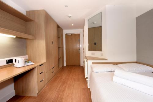 a bedroom with two beds and a desk and a mirror at Juniper Court in Stirling