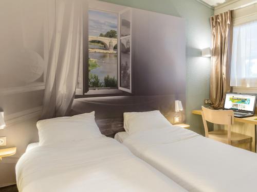 une chambre d'hôtel avec deux lits et une fenêtre dans l'établissement B&B HOTEL Tours Nord 1 Val de Loire, à Tours