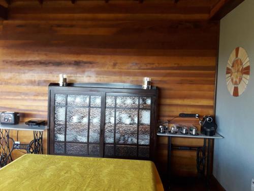 a bedroom with a bed and a wooden wall at Pousada Vale Do Comandante in Macacos