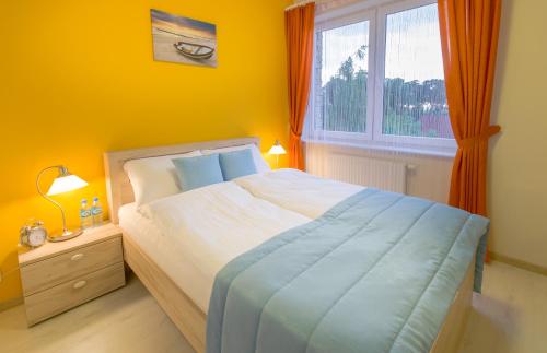 a bedroom with a bed and a window at Apartamenty Solaris Premium in Darlowko