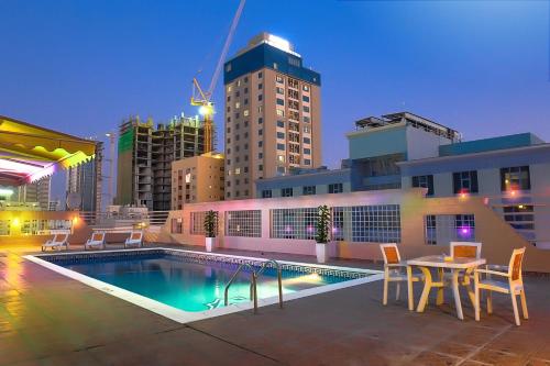 a pool with a table and chairs on a building at Sea Diamond Plaza Apartments in Manama