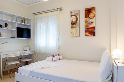 アテネにあるLovely Petit Apt in Athensの白いベッドルーム(ベッド1台、デスク付)